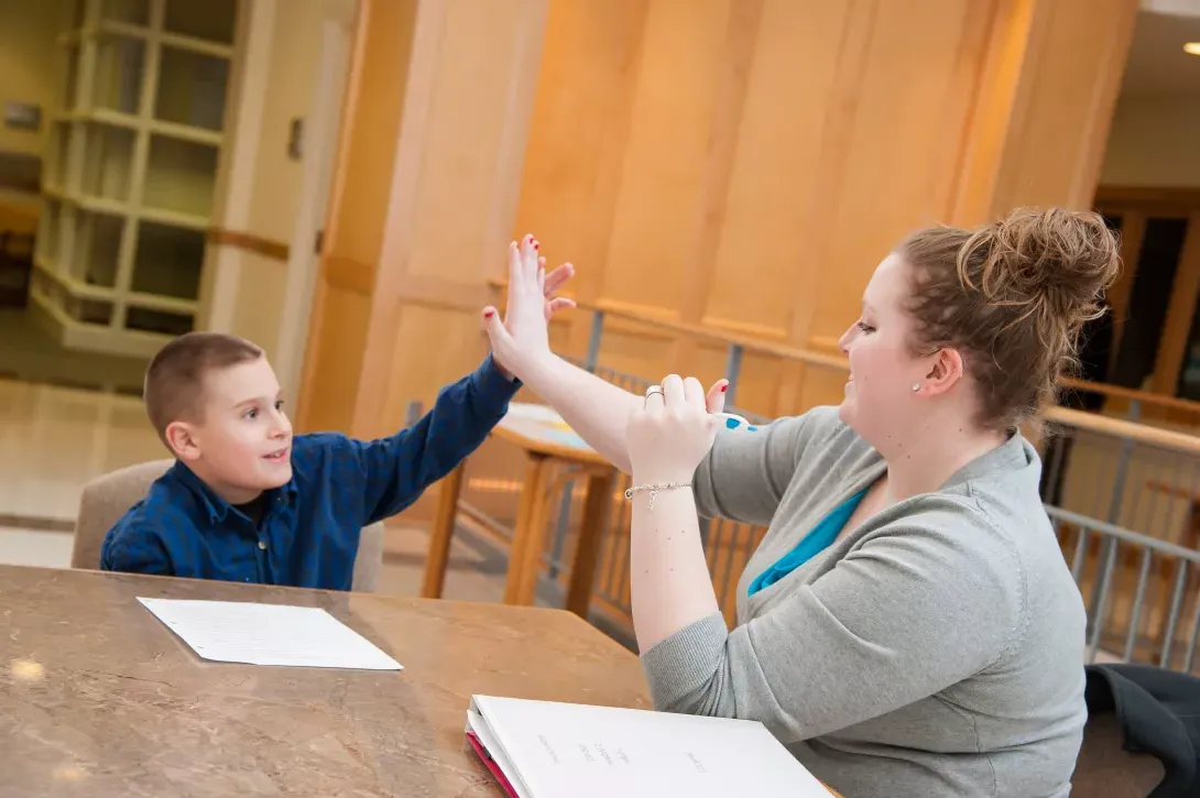 Student teacher with student in classroom